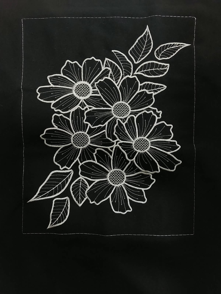 Bordir motif bunga dan daun dengan garis putih pada kain hitam