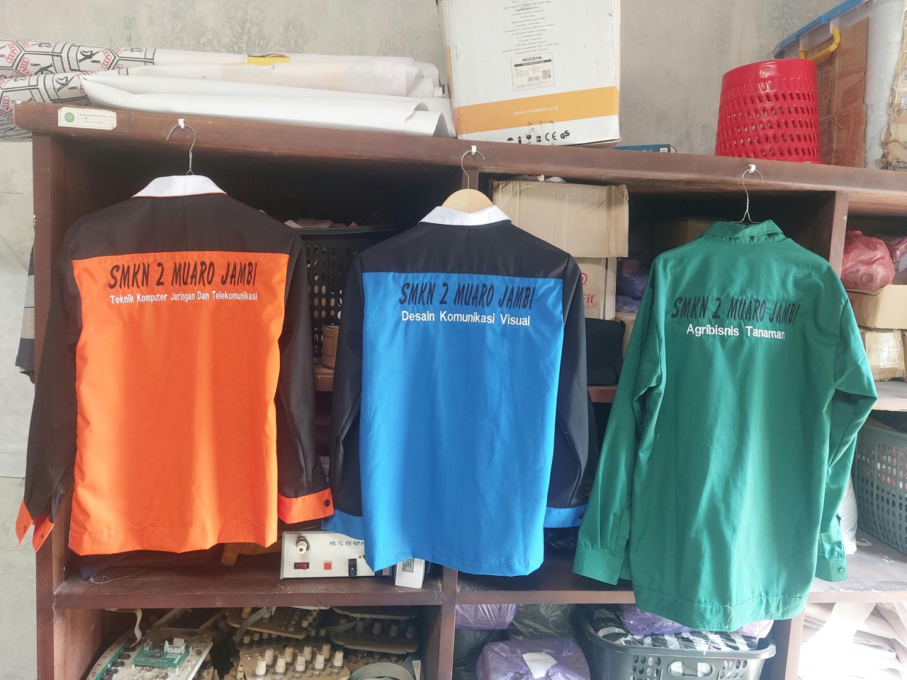 Tiga seragam dengan bordir punggung