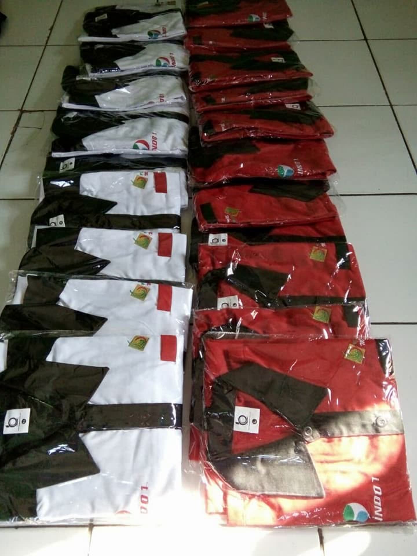 Tumpukan produk pakaian; sebagian terbungkus plastik. Jumlah pesanan dan kesiapan kirim tidak dapat dipastikan dari foto.