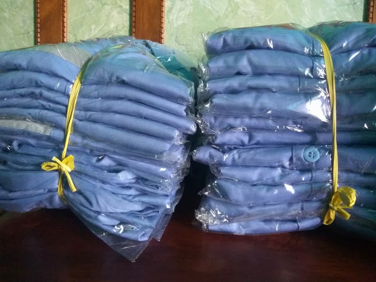 Tumpukan produk pakaian; sebagian terbungkus plastik. Jumlah pesanan dan kesiapan kirim tidak dapat dipastikan dari foto.