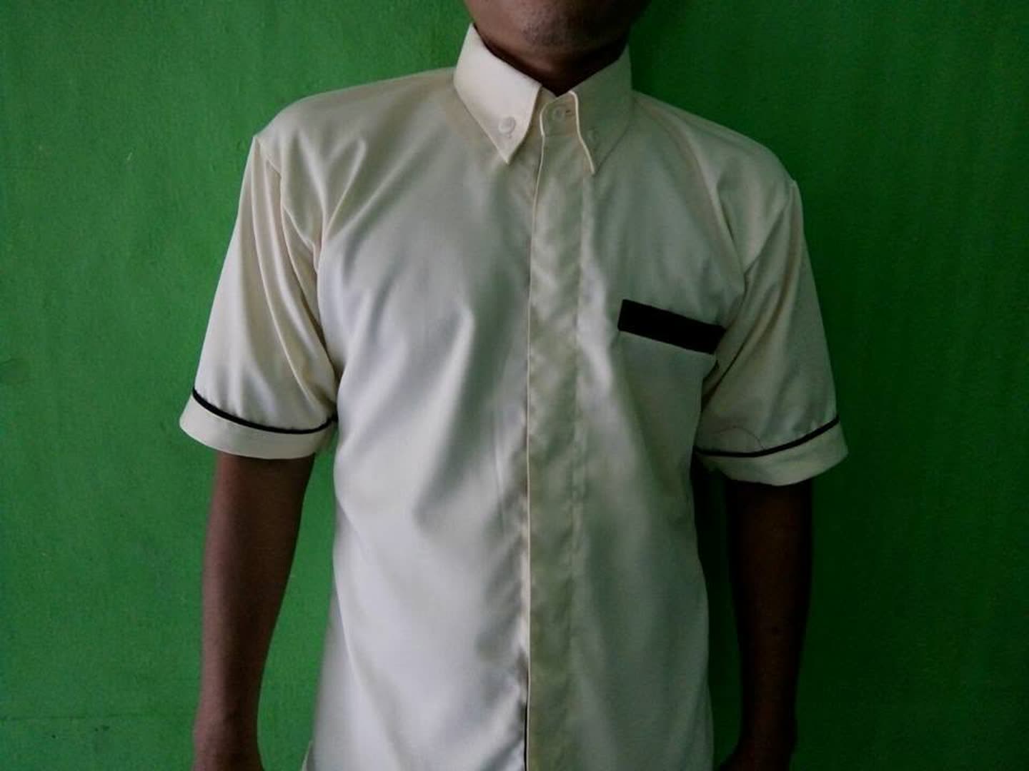 Baju putih berkerah tegak, lengan pendek dan detail hitam; dikenakan orang.