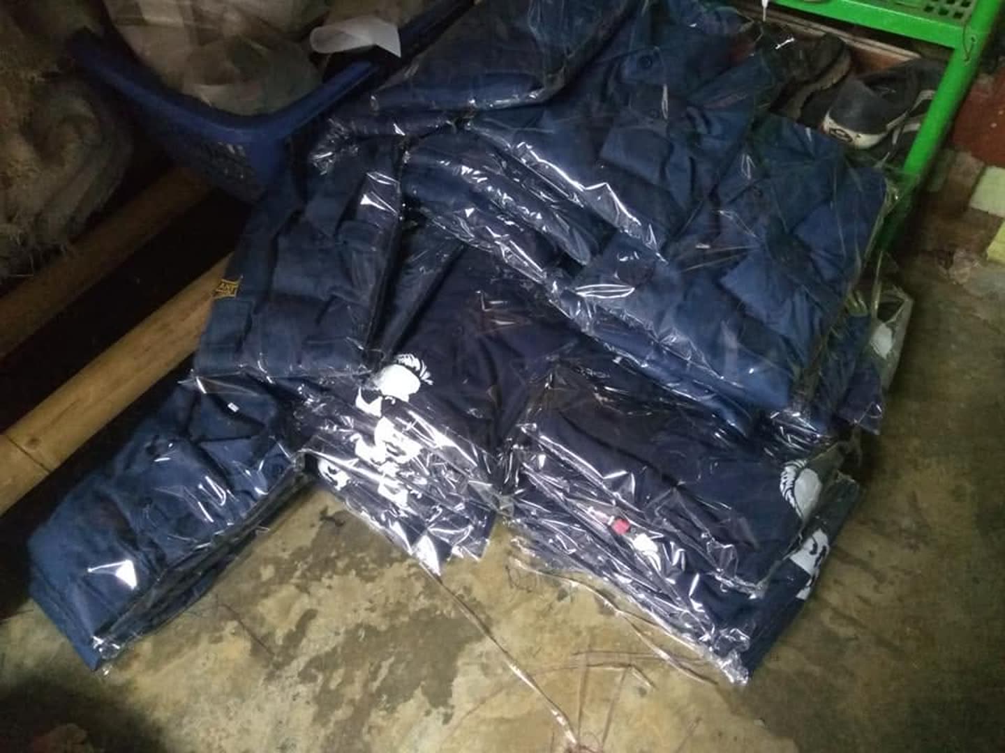 Tumpukan produk pakaian; sebagian terbungkus plastik. Jumlah pesanan dan kesiapan kirim tidak dapat dipastikan dari foto.