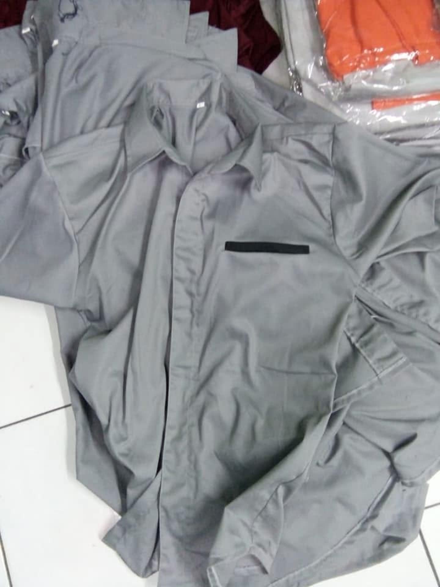 Tumpukan baju abu-abu dengan detail hitam.