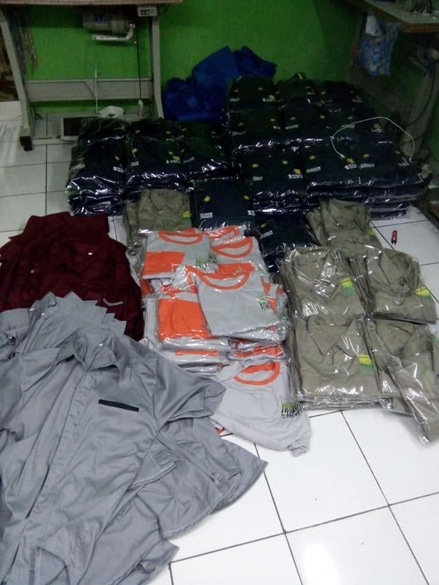 Tumpukan baju beberapa warna, sebagian sudah dalam kemasan.