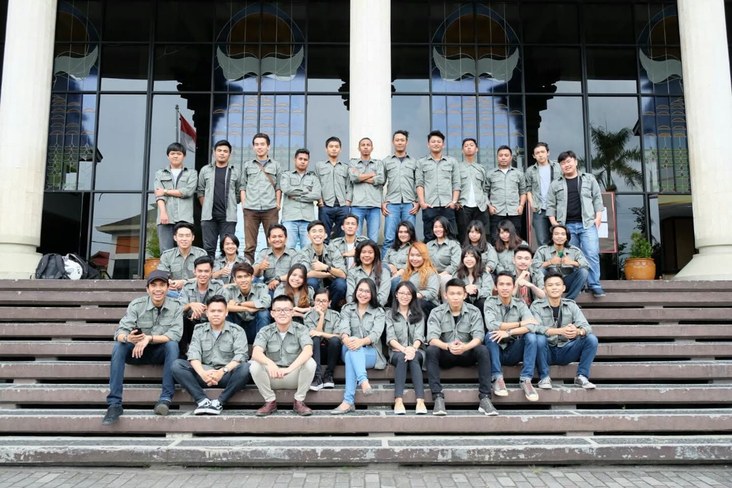Foto kelompok orang berseragam di depan bangunan; detail produk terbatas.