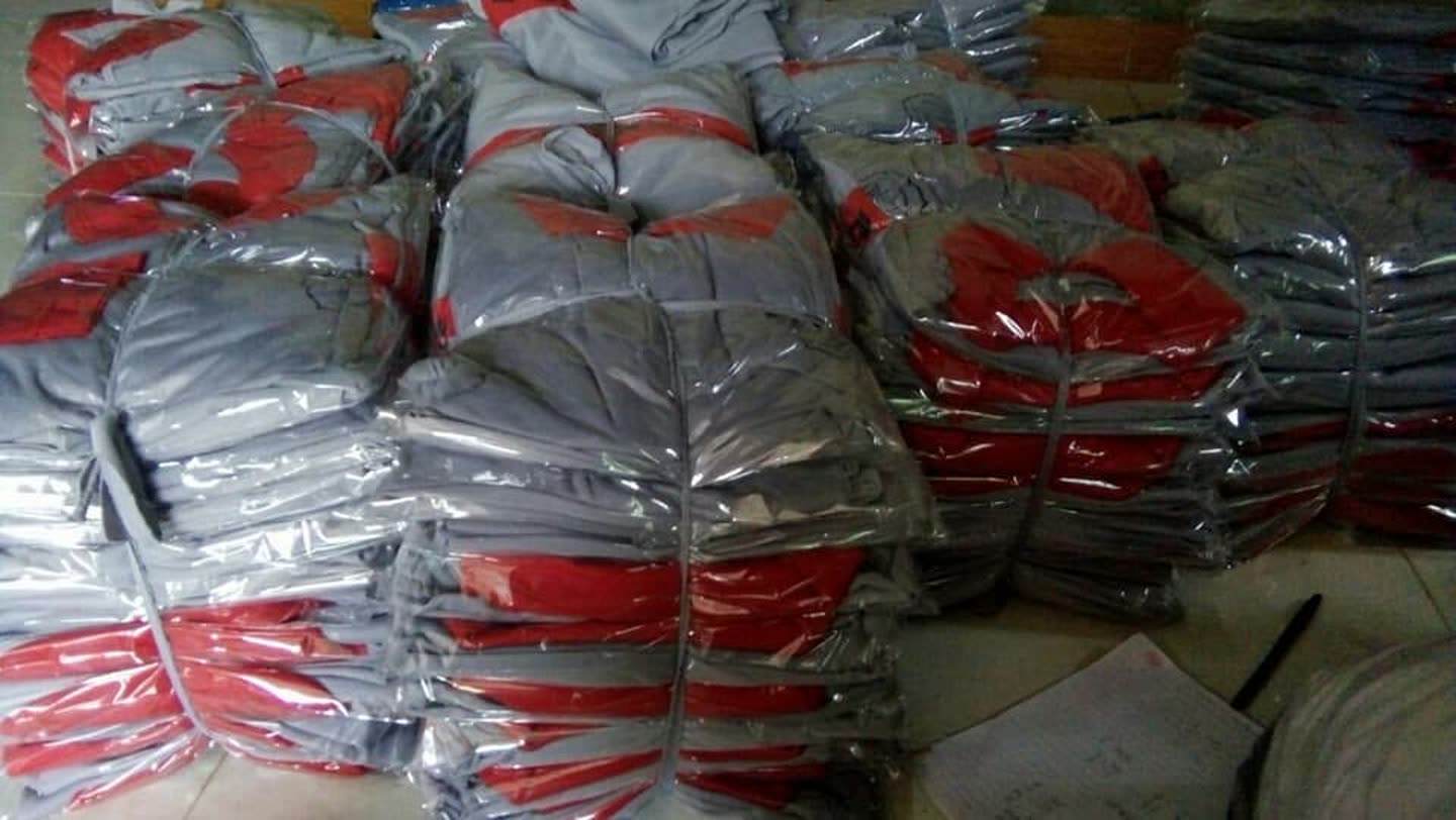 Tumpukan produk pakaian; sebagian terbungkus plastik. Jumlah pesanan dan kesiapan kirim tidak dapat dipastikan dari foto.