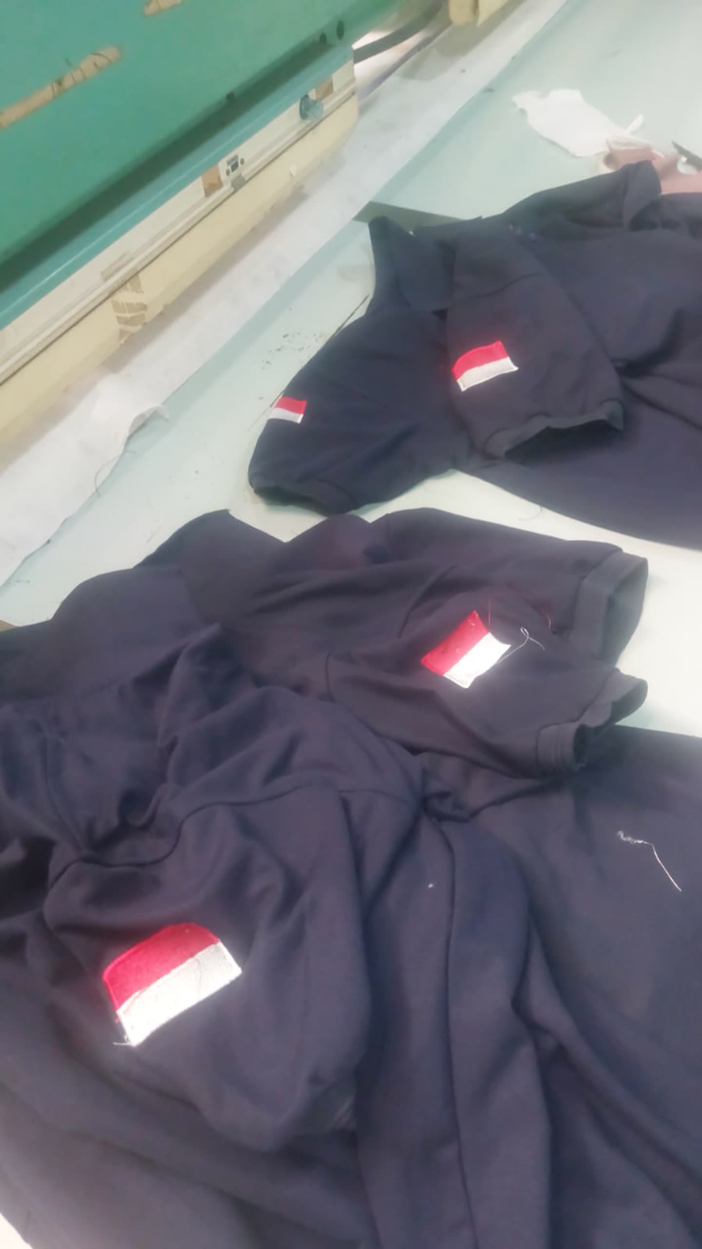 Kumpulan baju gelap dengan detail bendera merah putih.