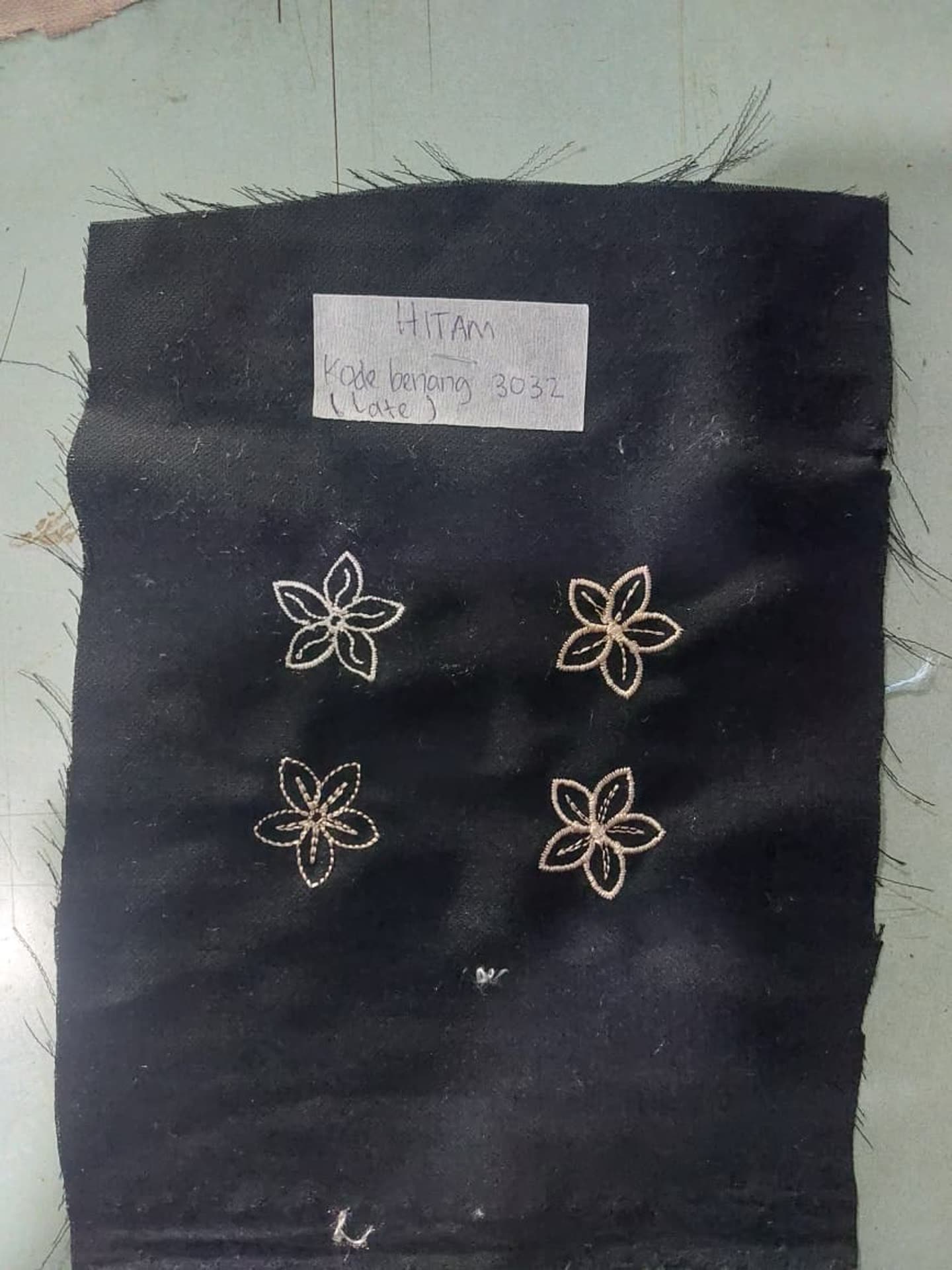 Beberapa motif bunga kecil pada kain gelap.