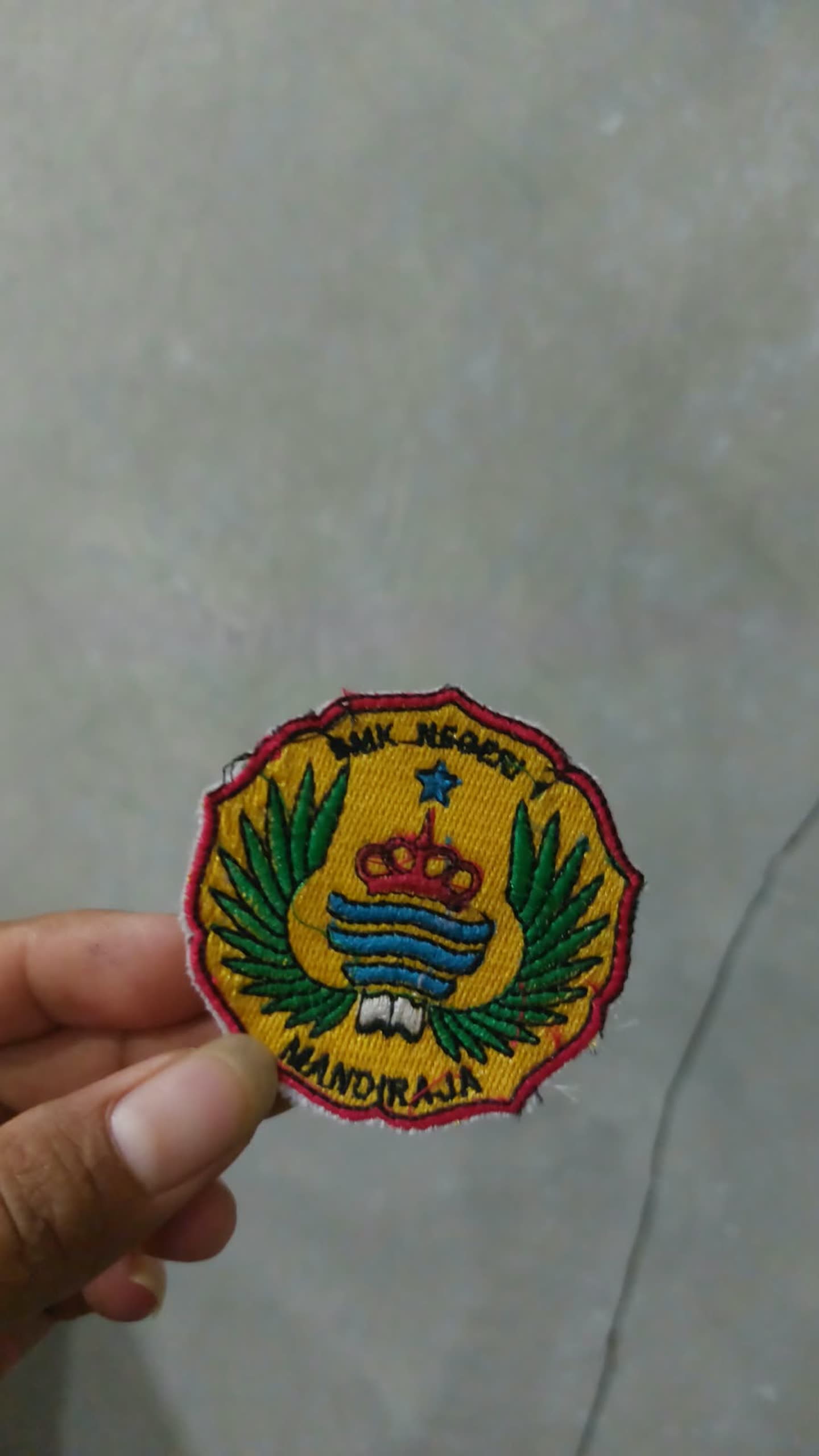 Emblem bentuk tepi bergelombang di tangan.